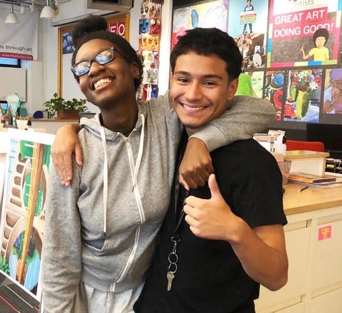 Two young men standing next to each other in a room
